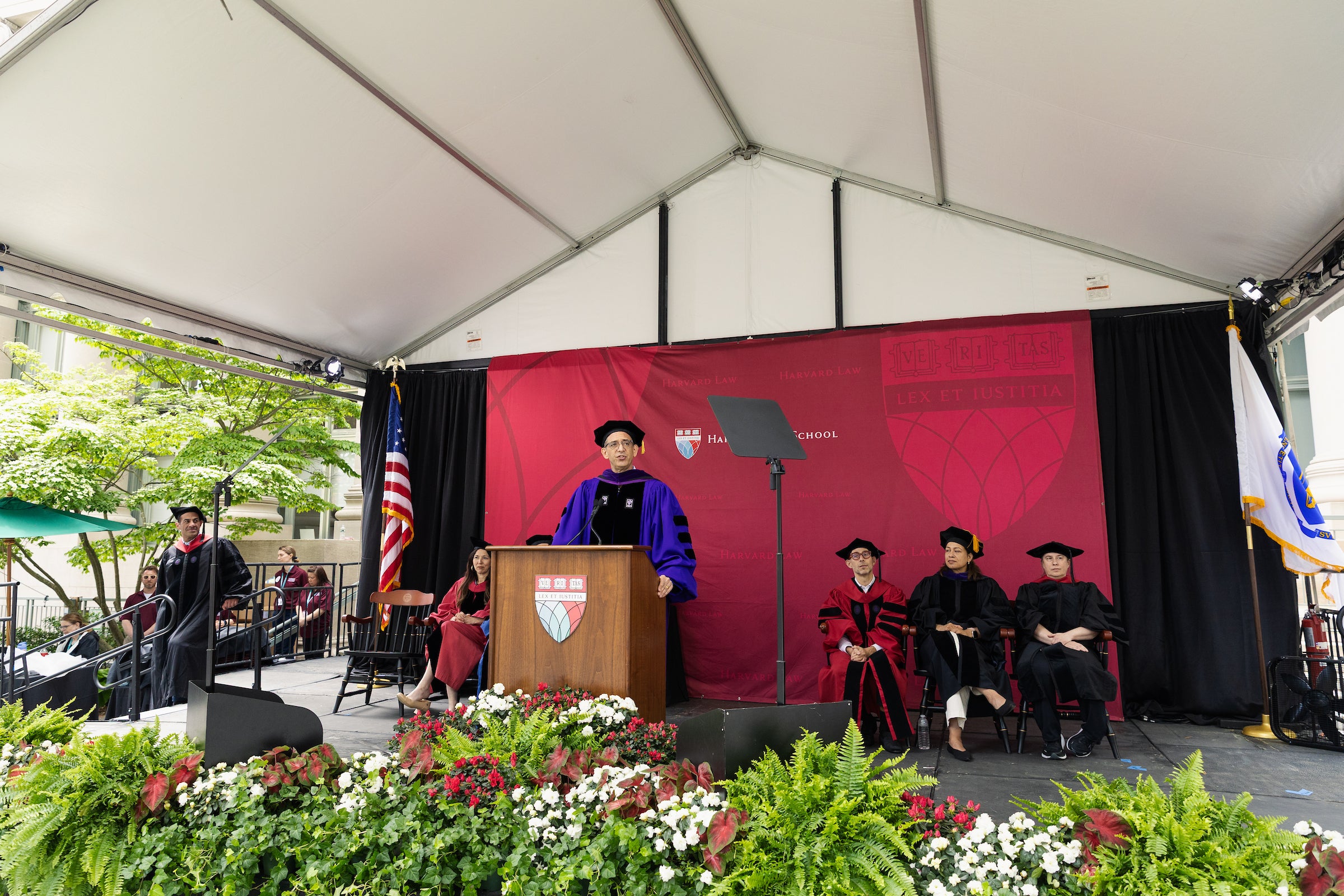 Dean Goldberg speaks onstage at a podium during commencement.