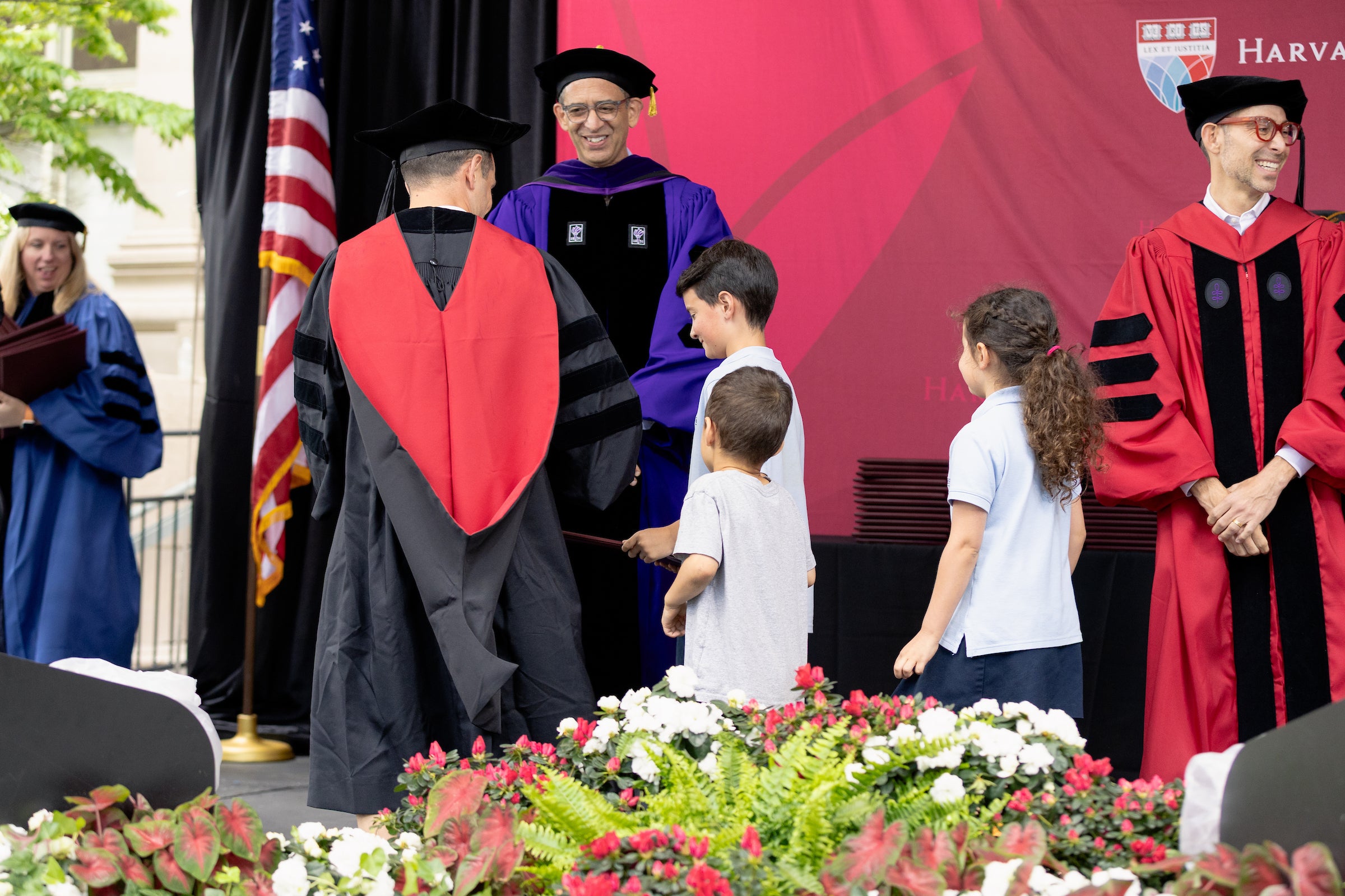 Dean Goldberg congratulates a graduate who is accompanied by his three children.