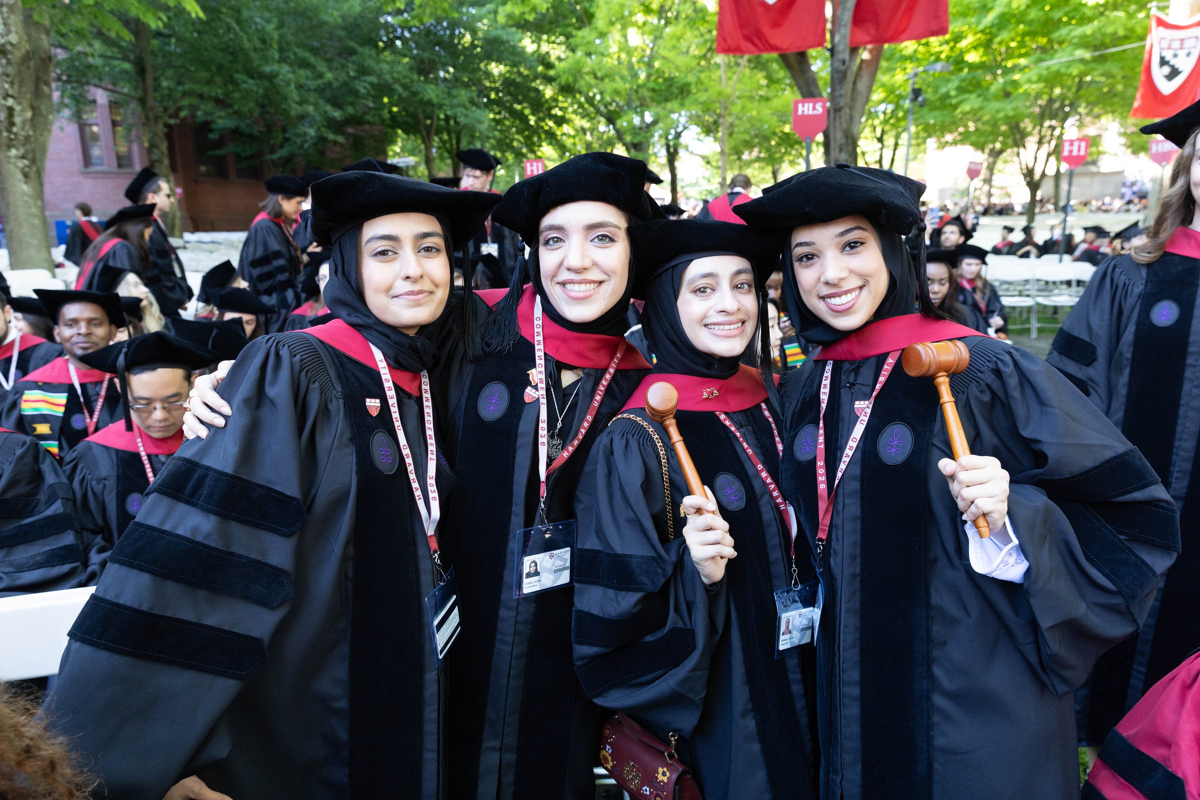 Four graduates smile for the camera with their gavels.