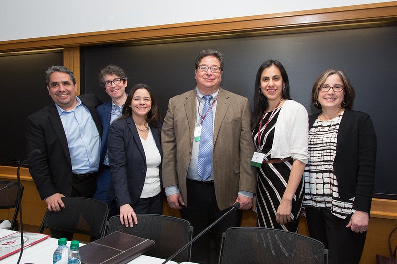 Alumni and speakers posing together for a photo in a classroom