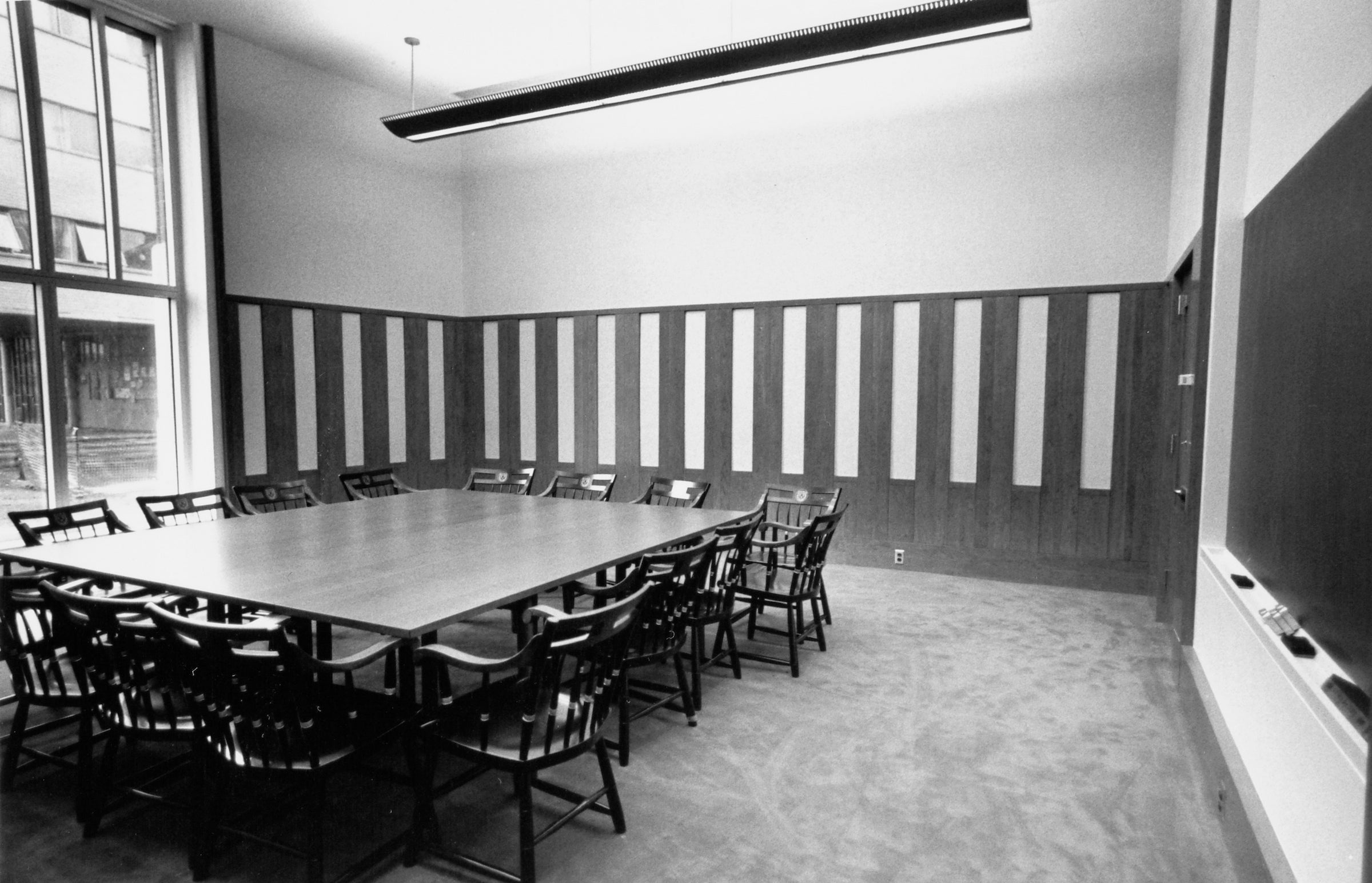 A large table surrounded by chairs in a classroom.