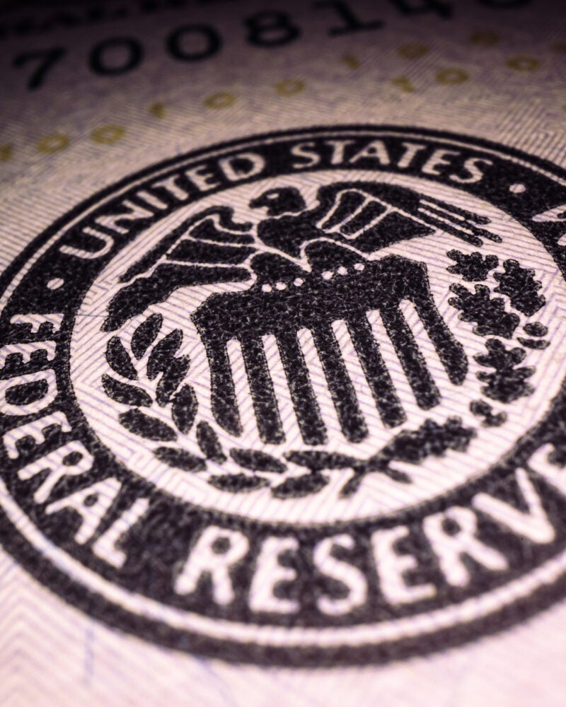 Federal Reserve System stamp on a $100 bill.