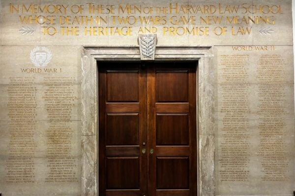 Memorial wall with inscription over names of alumni lost in world war 1 and 2 reads: In memory of these men of the Harvard Law School whose death in two wars gave new meaning to the heritage and promise of law.