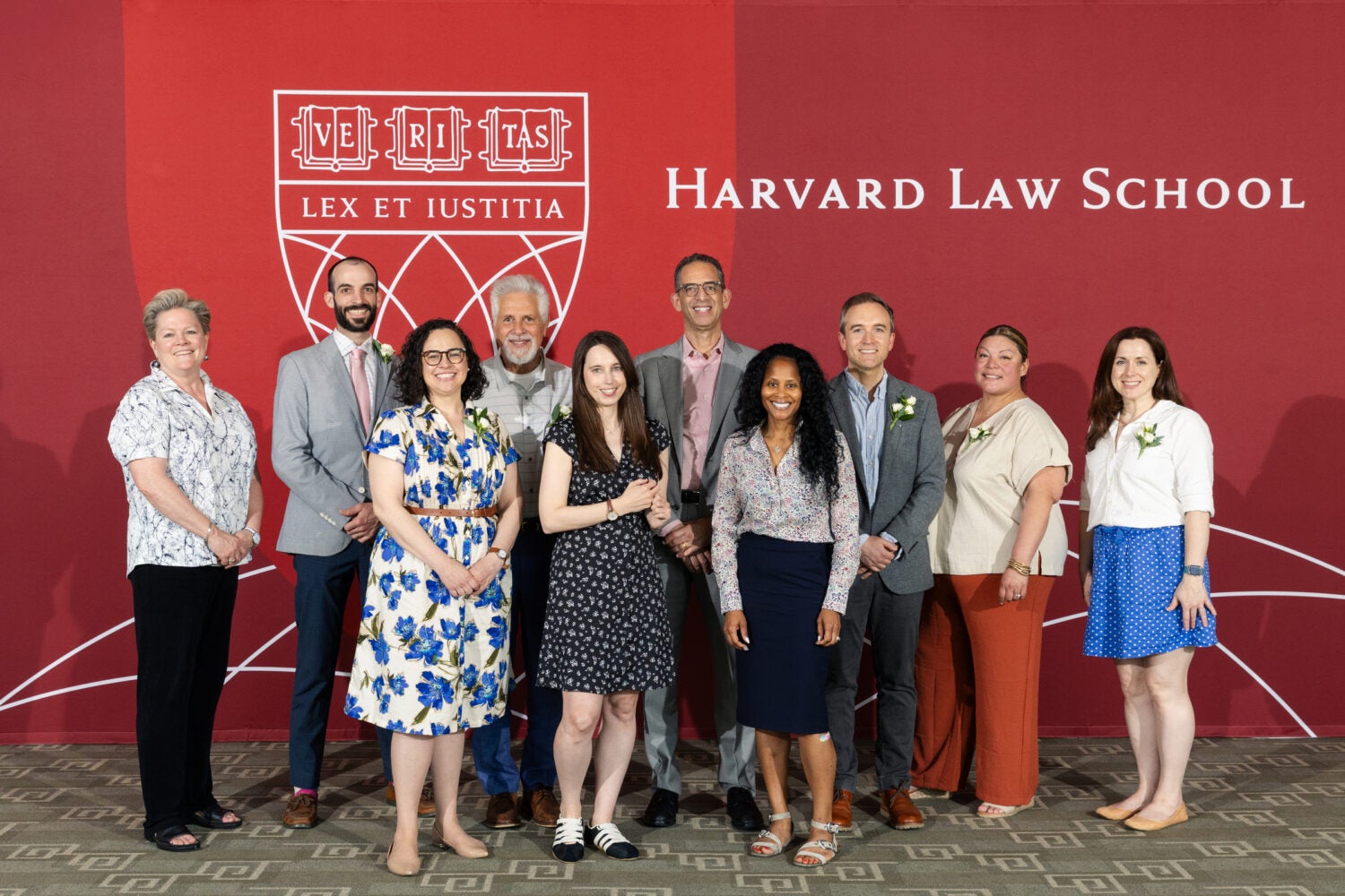 Group posing for photo in front of a Harvard Law School banner.