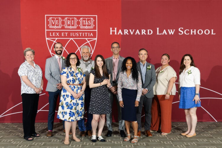 Group posing for photo in front of a Harvard Law School banner.