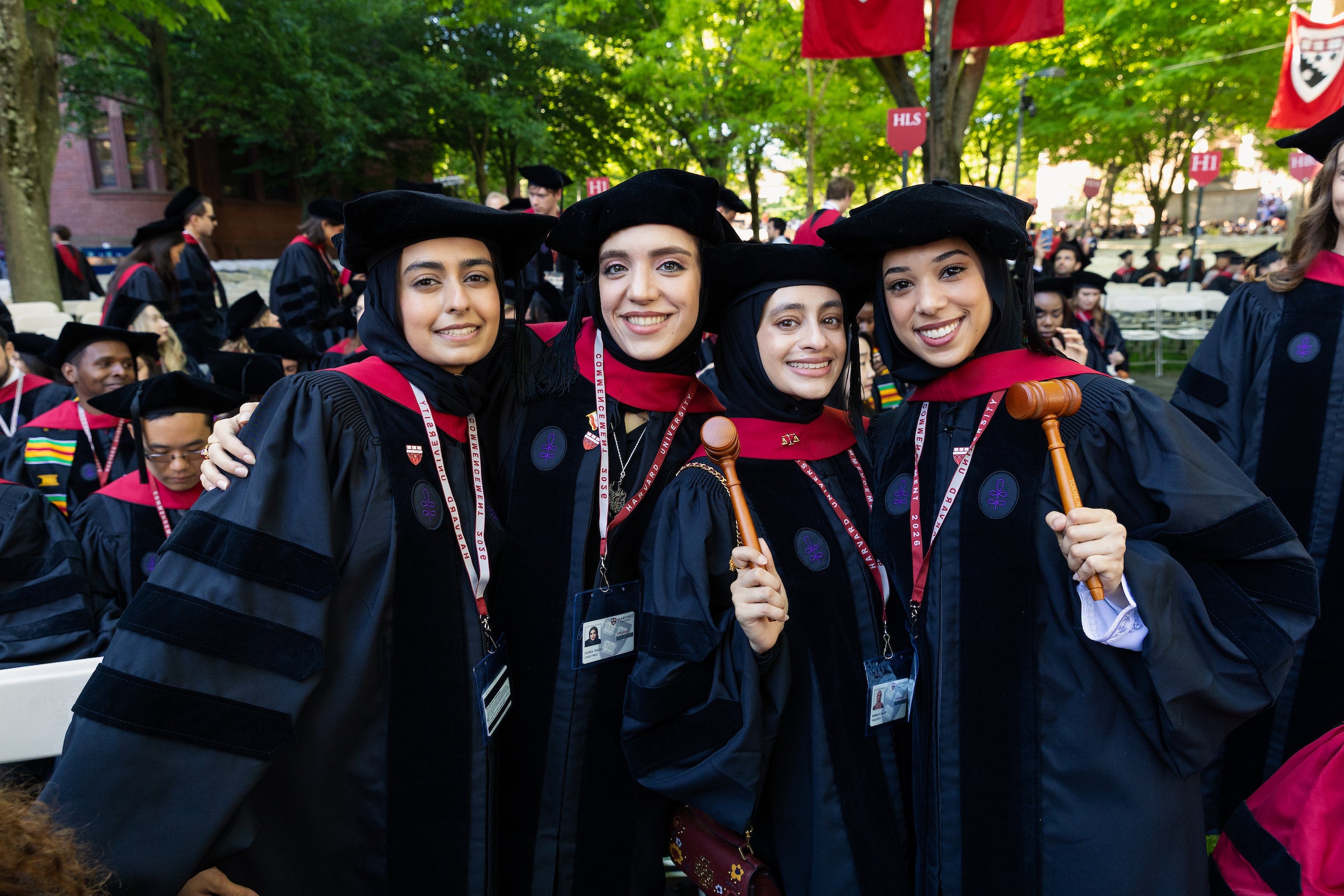 Four graduates smile for the camera with their gavels.