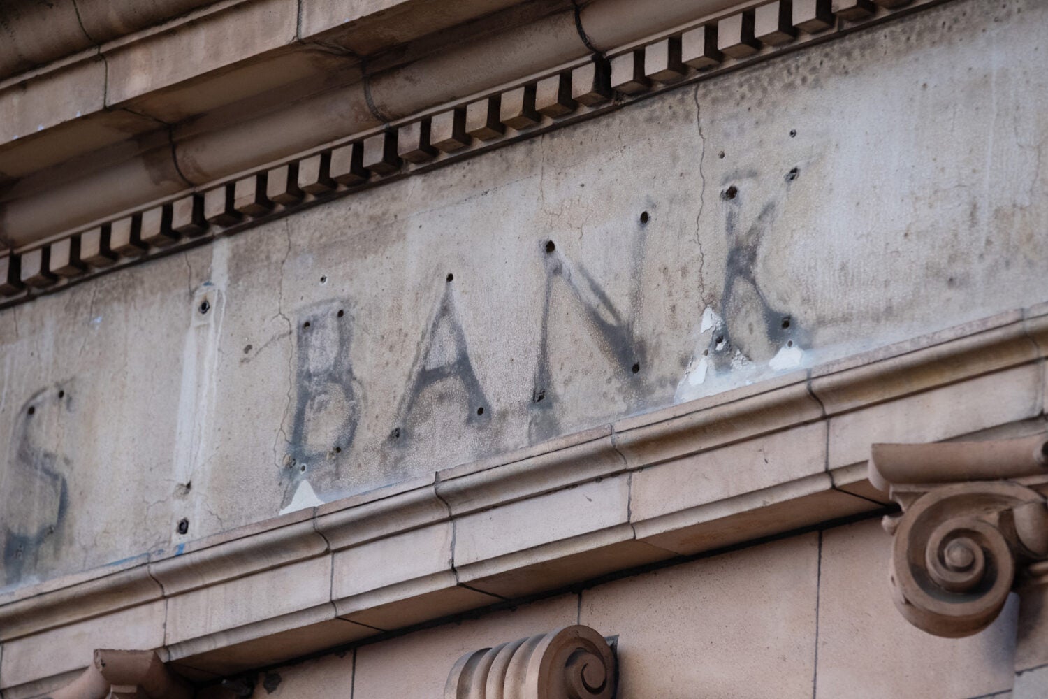 The remains of a sign over a former bank branch.