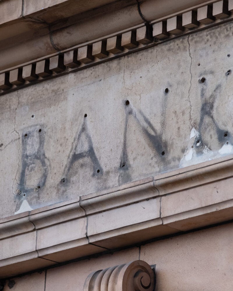 The remains of a sign over a former bank branch.