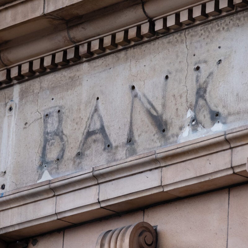 The remains of a sign over a former bank branch.