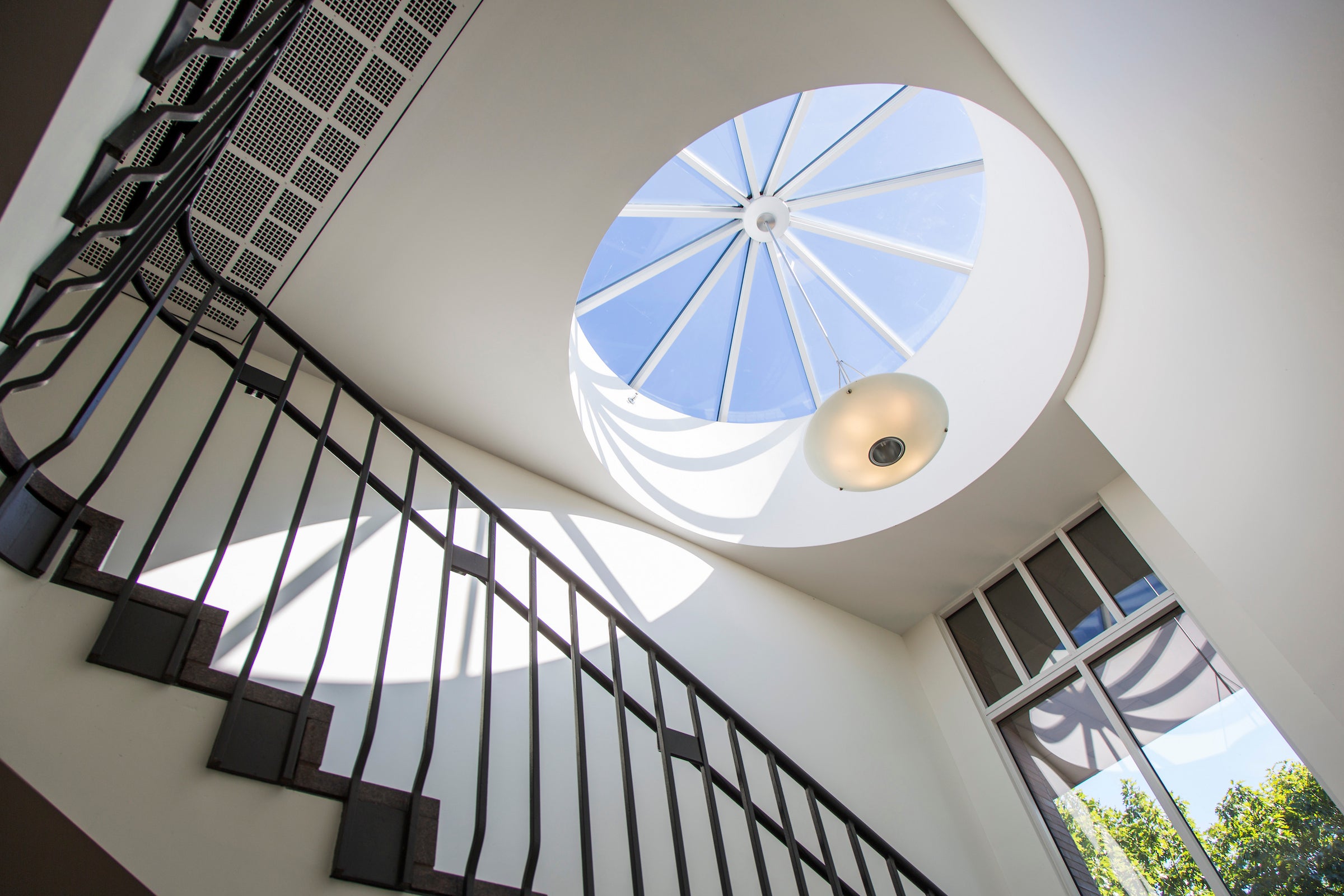 A view to the skylight at the top of a spiral staircase.