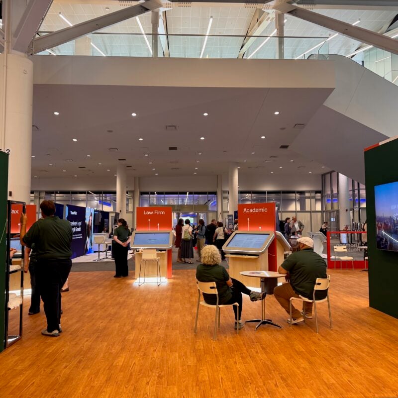 The Thomson West/Westlaw exhibit at AALL with demonstration kiosks, display screens, and booths labeled “Law Firm” and “Academic.”
