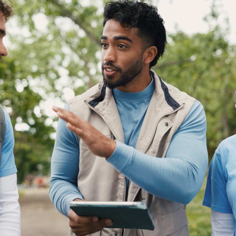 Volunteer, tablet and team outdoor for meeting