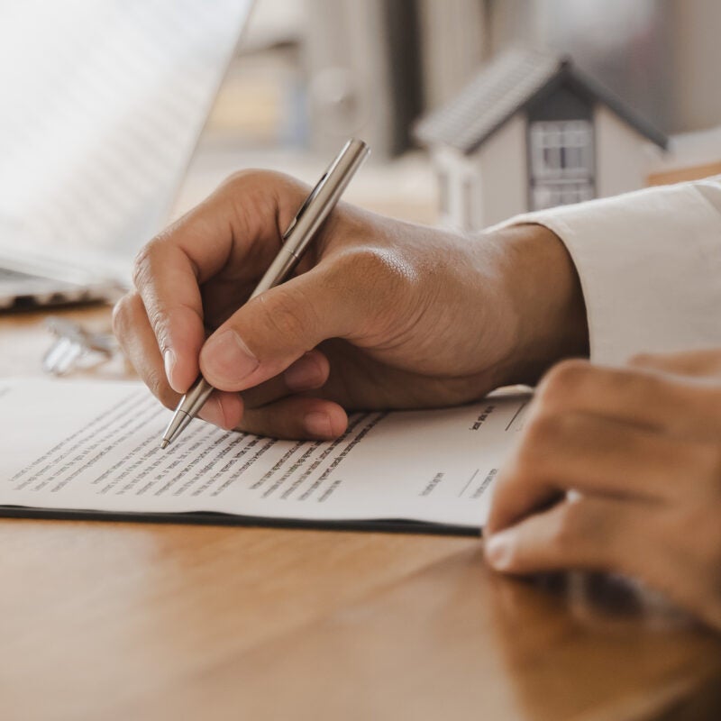 Image of hand signing legal document