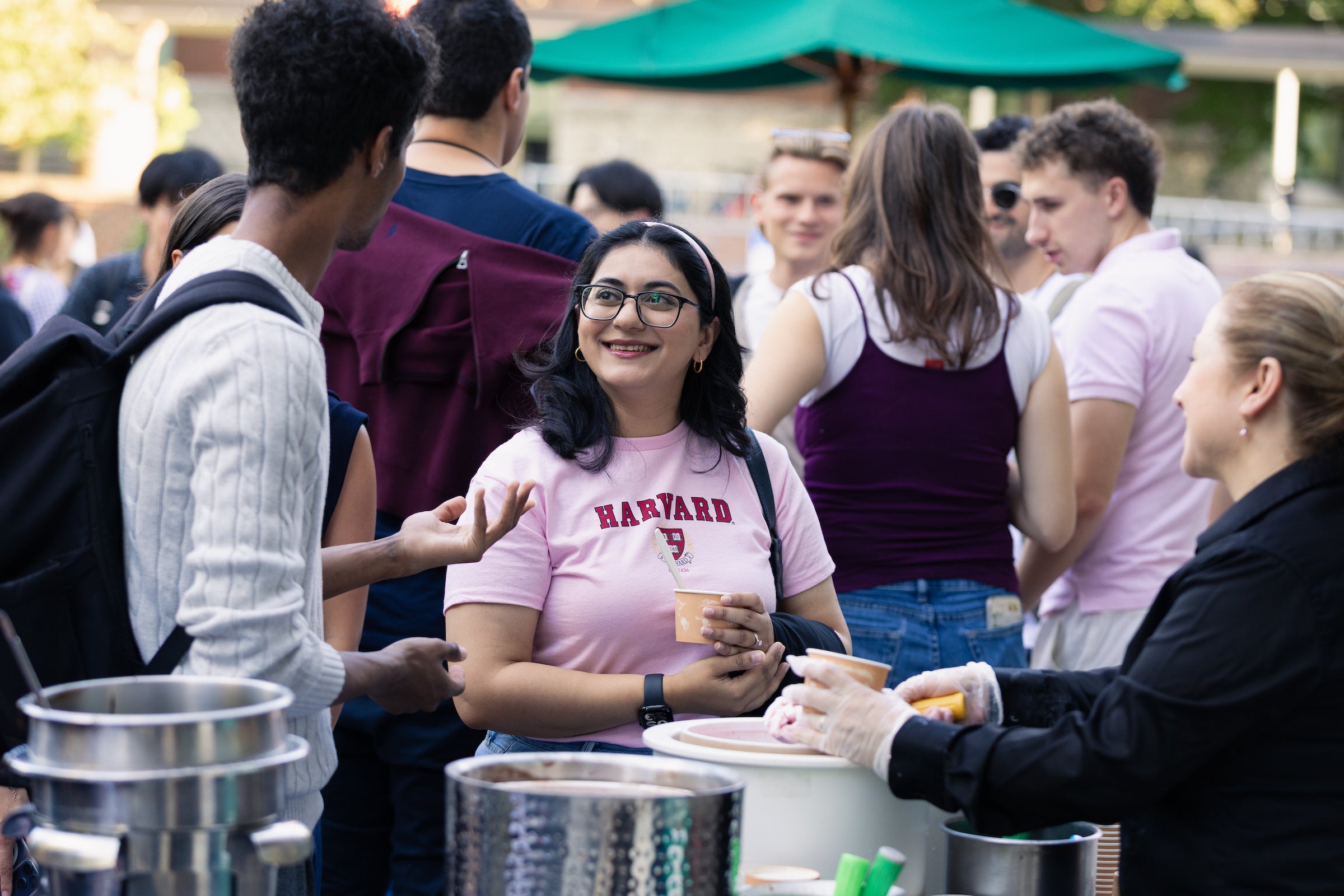 Students converse while getting ice cream at an outdoor event.
