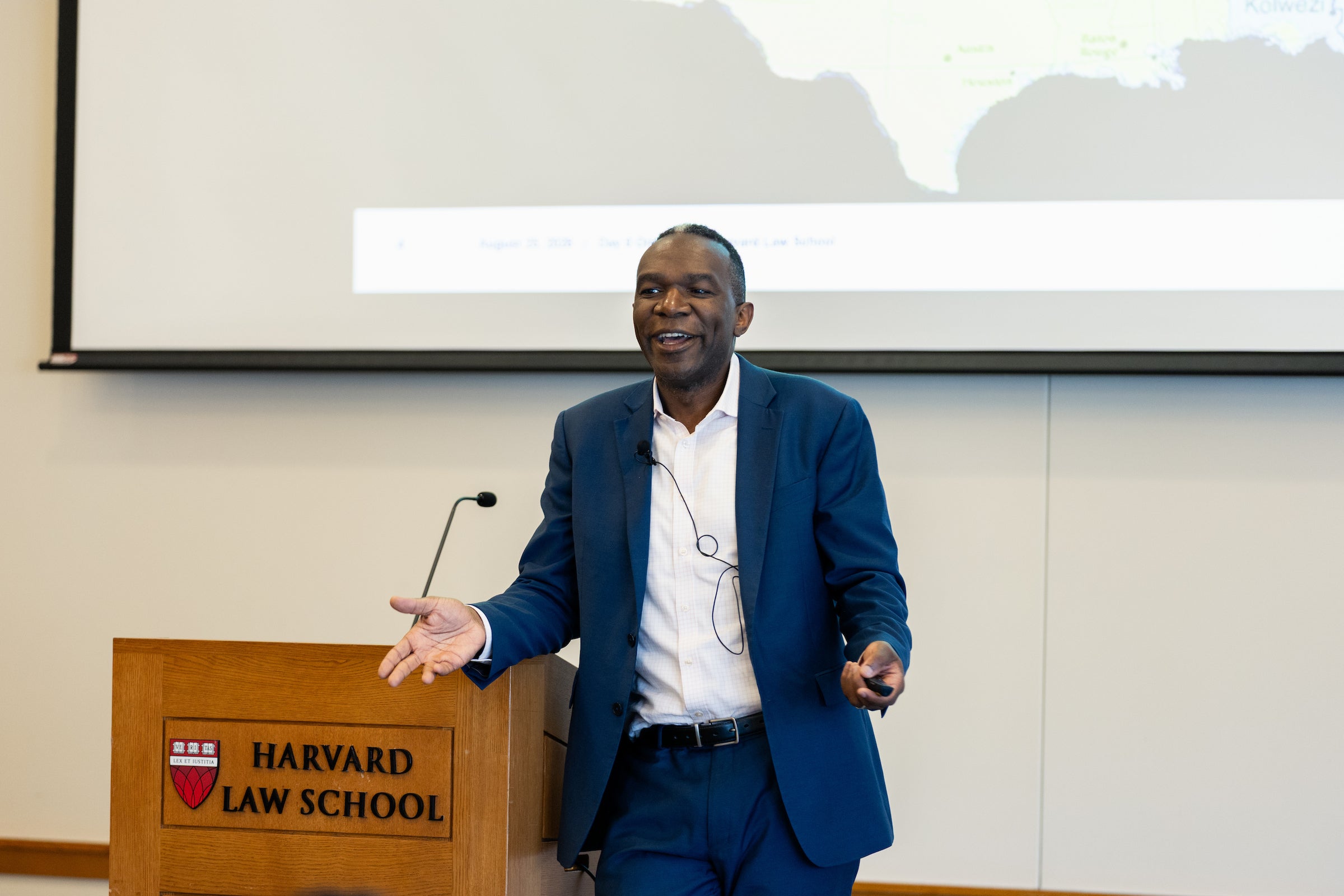 An individual speaks to an audience while leaning on a podium.
