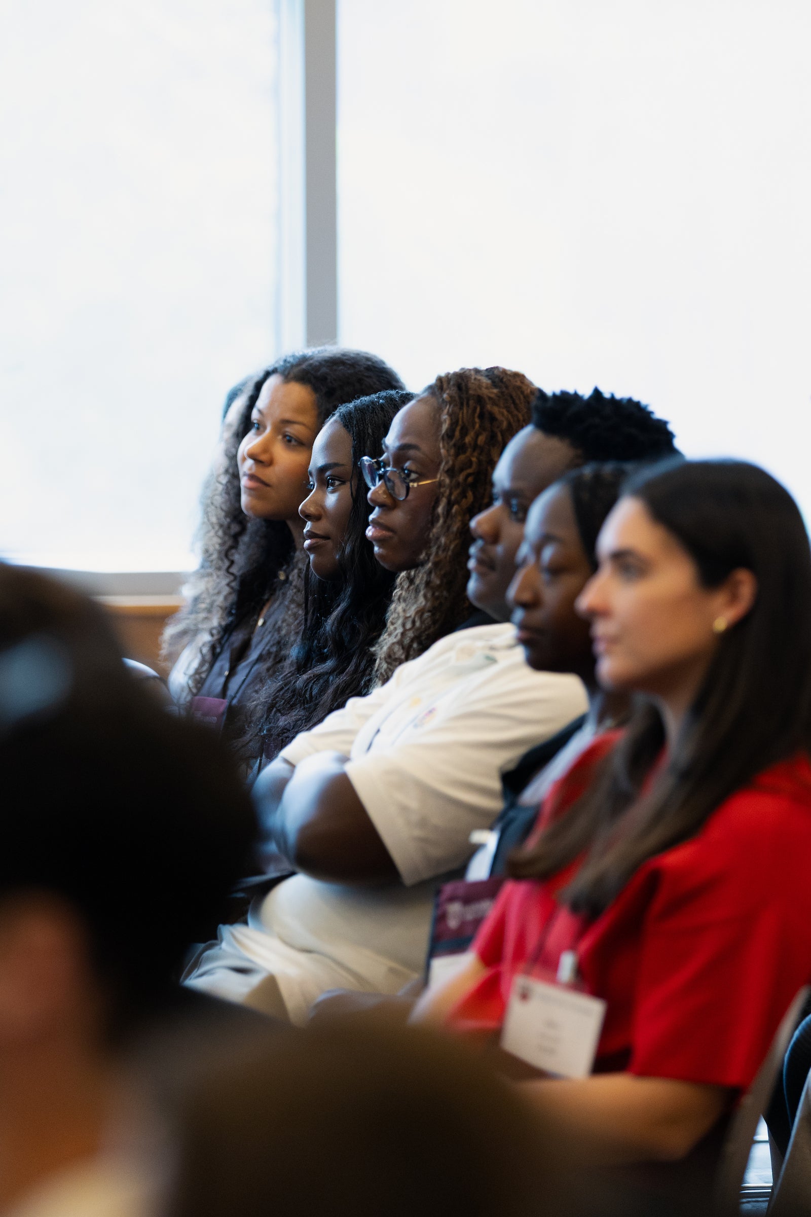 Students sitting in an audience listen to a speaker.