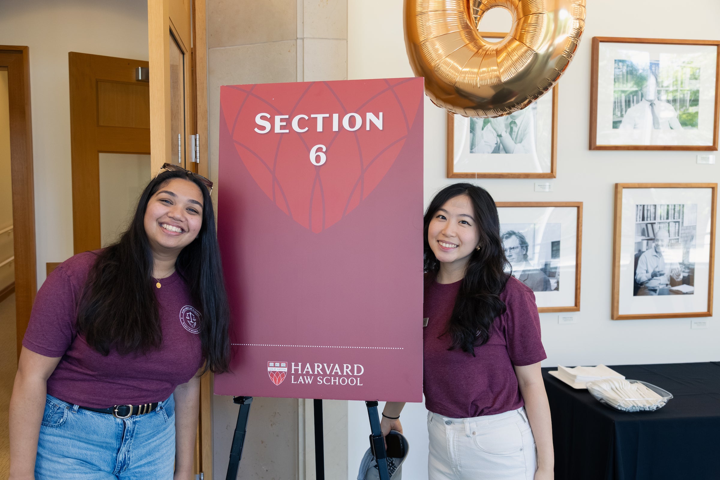 Two students pose with a sign that says 