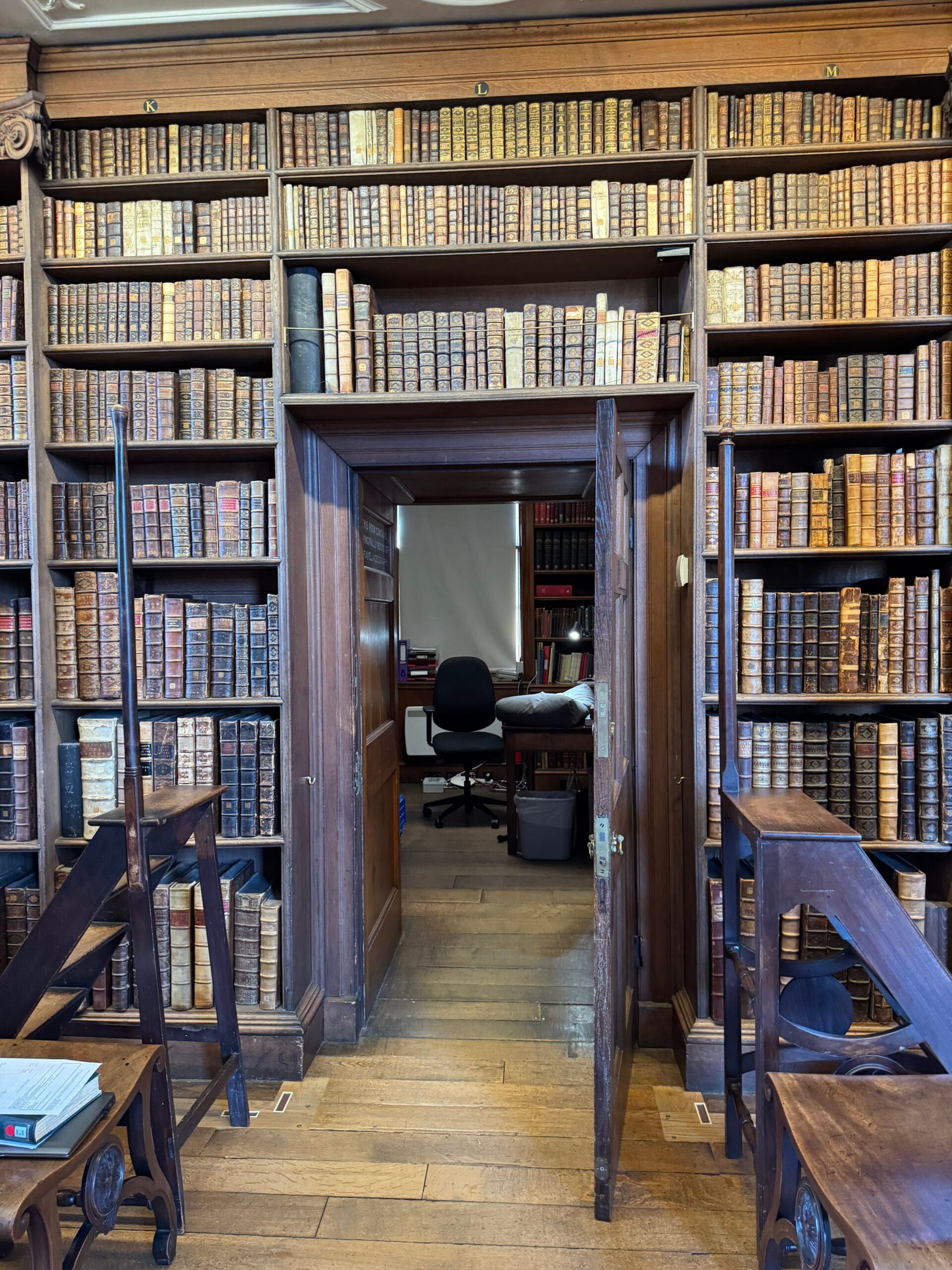 Floor to ceiling bookcases surrounding an open door.