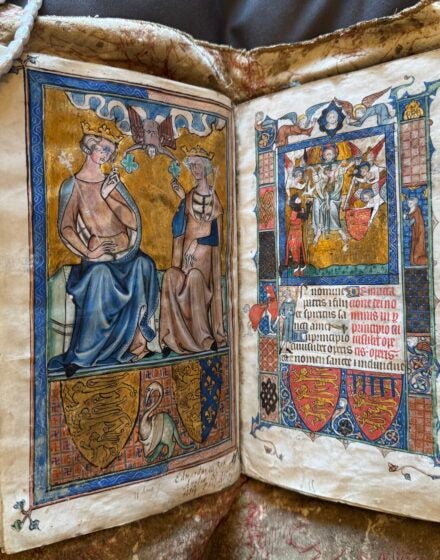 Open old book with colorful drawings on both sides.