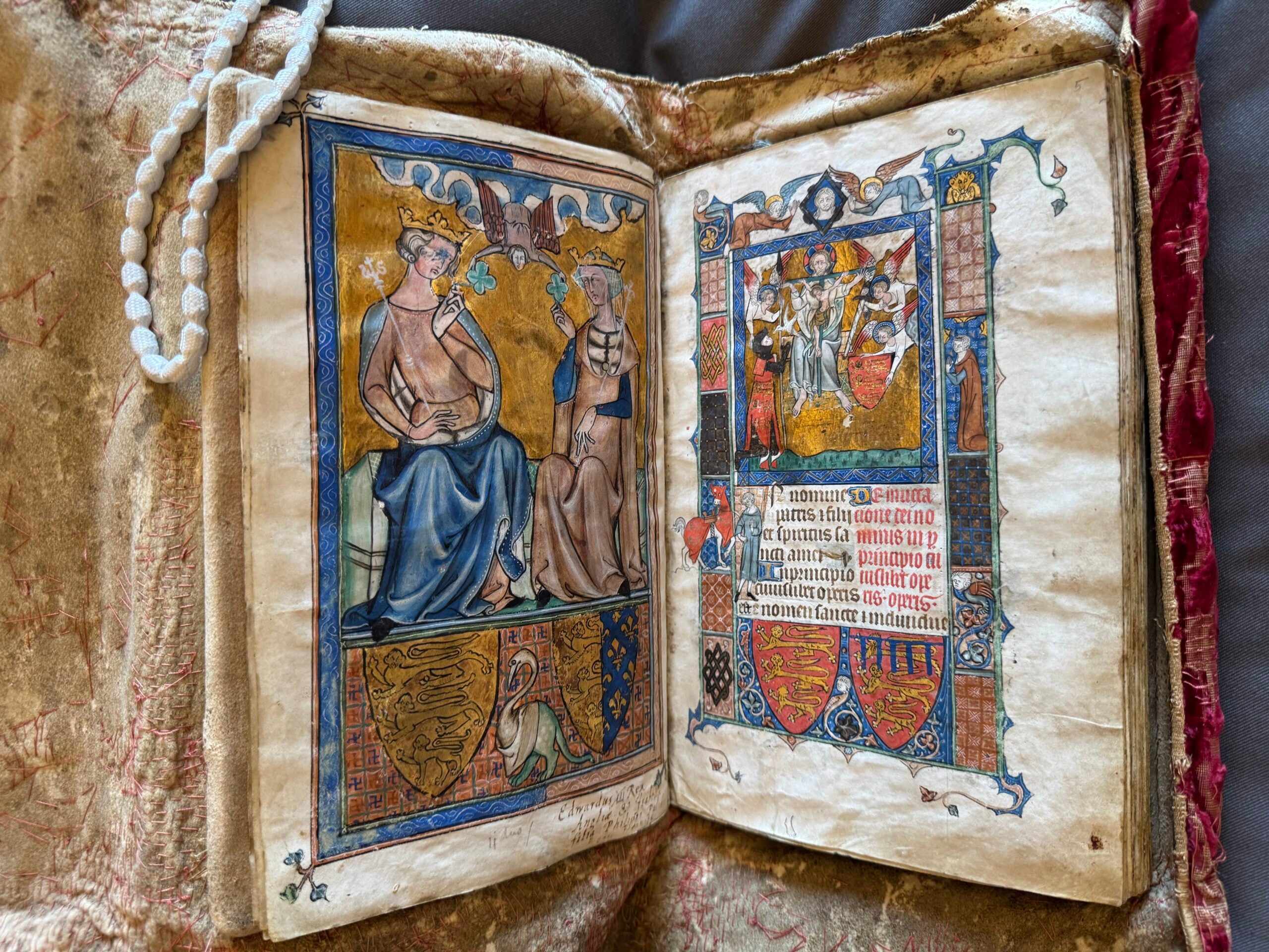 Open old book with colorful drawings on both sides.