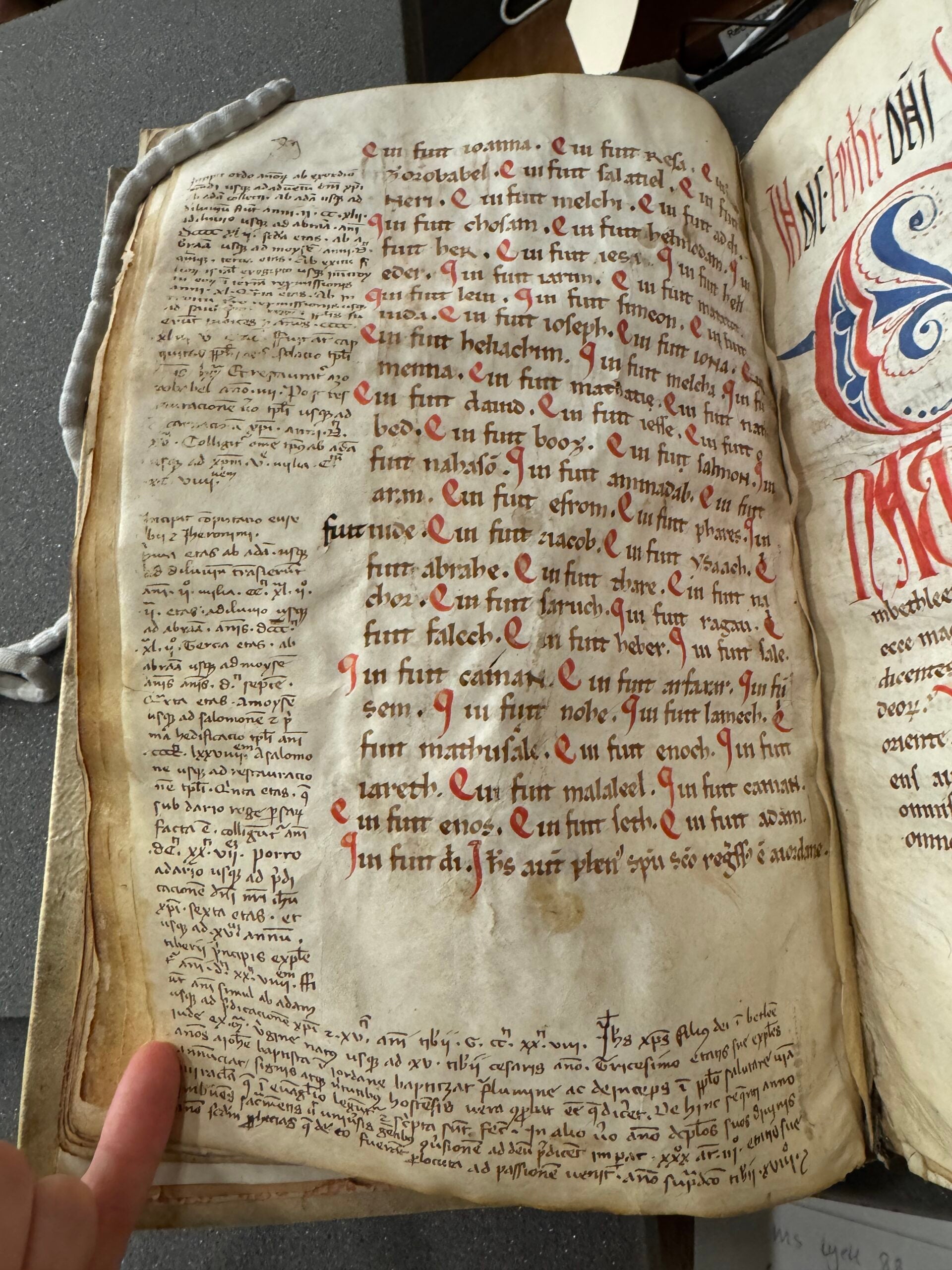Open folio with wrinkled yellow pages. Some text is in bright red and includes blue and red decoration.