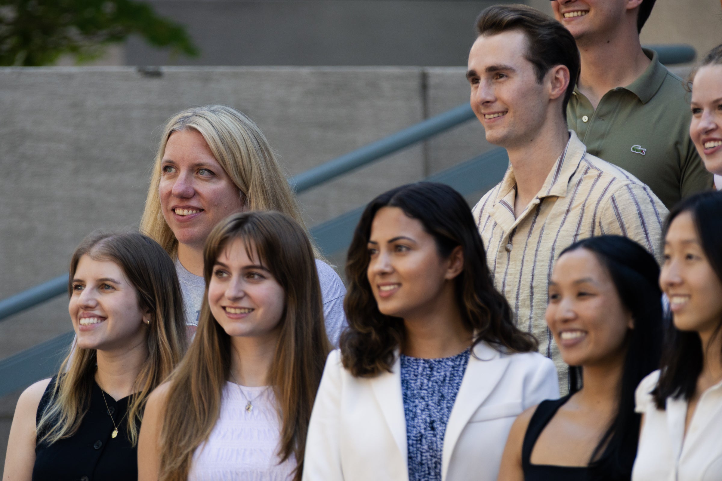 A smaller portion of a large group of people smiling for a photo on steps.