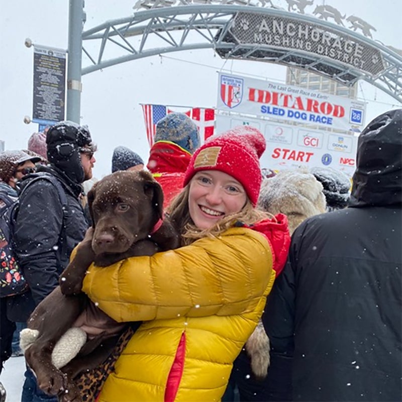 Eva Venema holding a dog in a snowy setting.