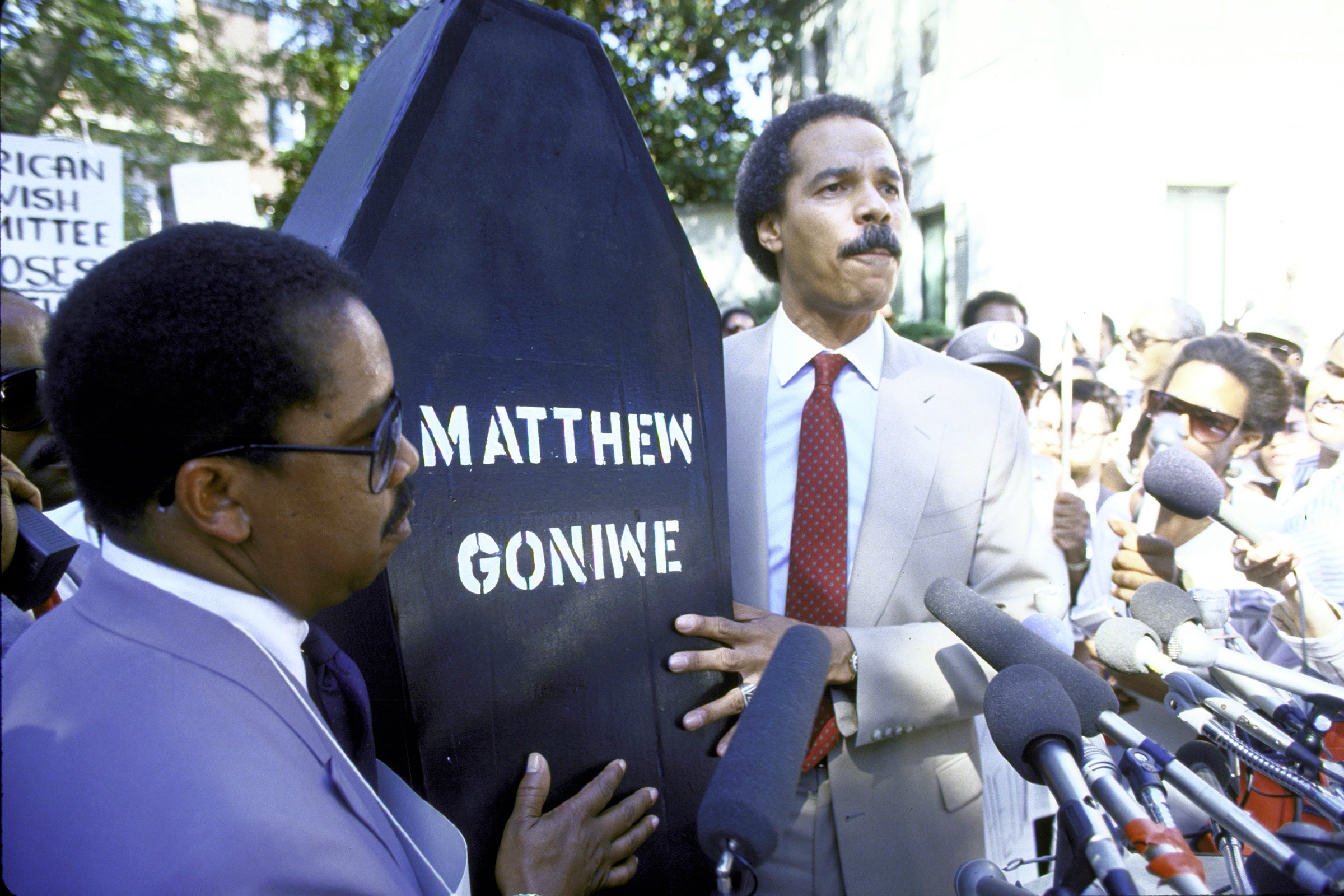 John Jacob and Randall Robinson carrying a coffin with the name of murdered UDF activist Matthew Goniwe.