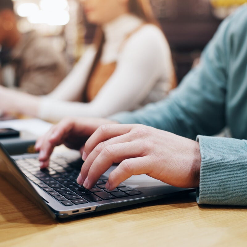 a student in class typing on a laptop.