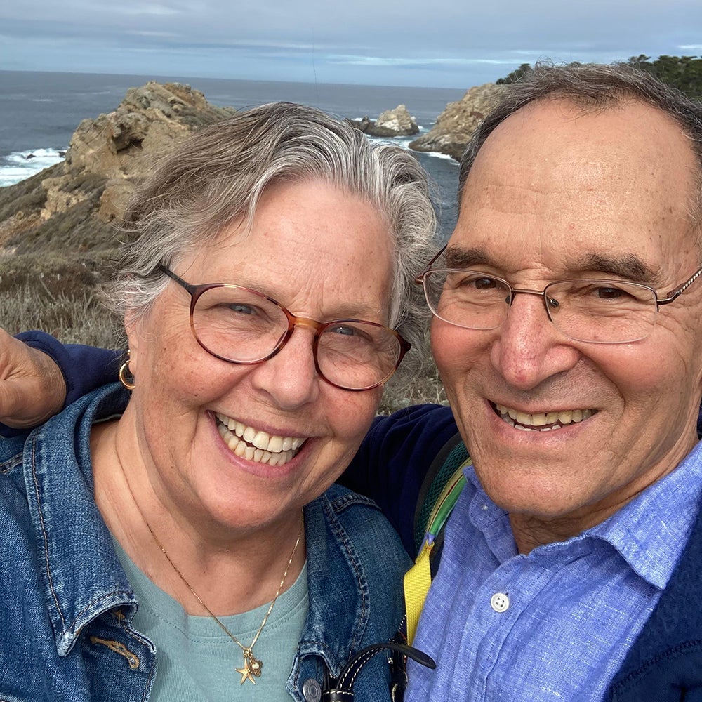 Lawrence Demille-Wagman and wife smiling in front of the ocean