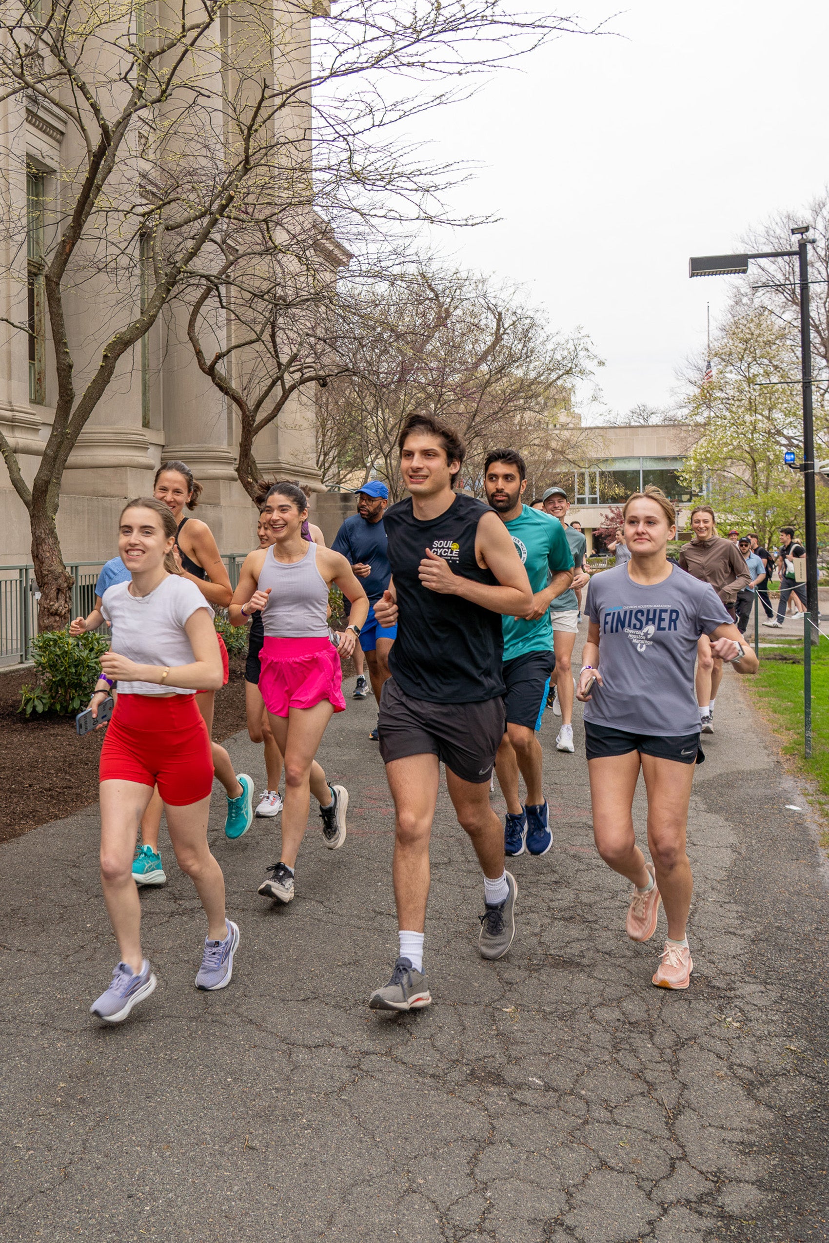 A group of students running on campus in the spring.