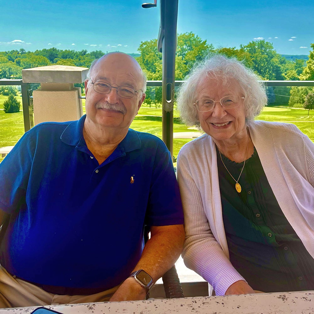 Ora Smith and husband outside sitting down