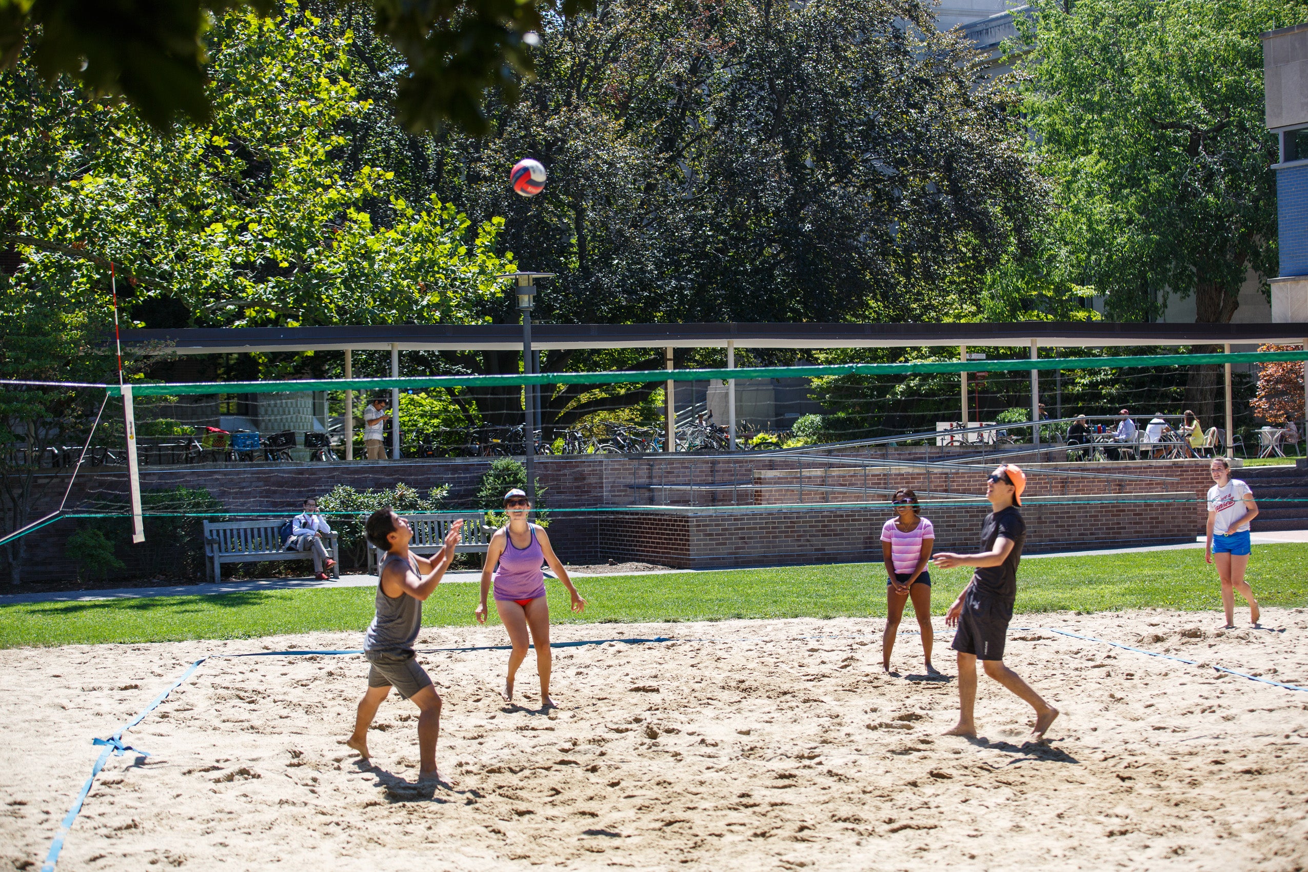 A group of students playing volleyball on a late summer day.